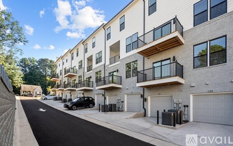 A street view of apartment buildings with cars parked on the side.