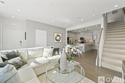 A living room with a white couch and a glass coffee table.