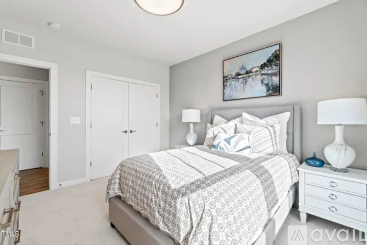 A bedroom with a bed, nightstand, and a painting on the wall.