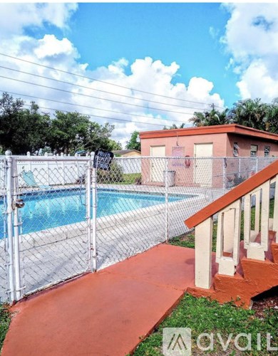 A red house with a pool and a fence.