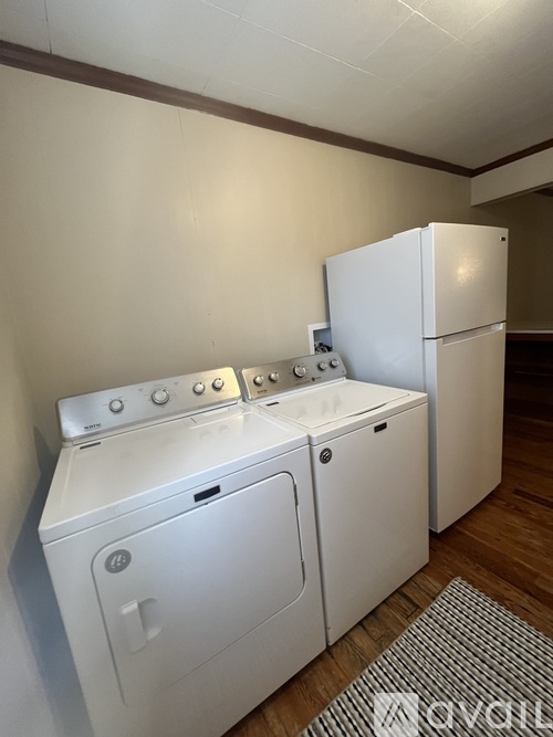 A white washing machine and dryer in a laundry room.