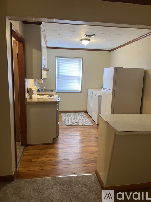 A kitchen area with a refrigerator, sink, and cabinets.
