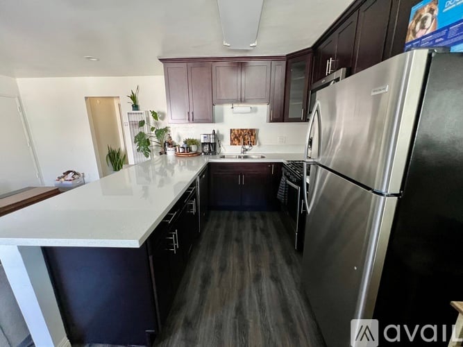 A kitchen with a white countertop and a stainless steel refrigerator.