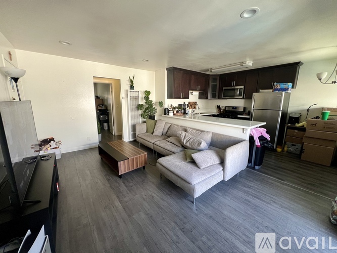 A modern kitchen with a grey couch and a wooden coffee table.