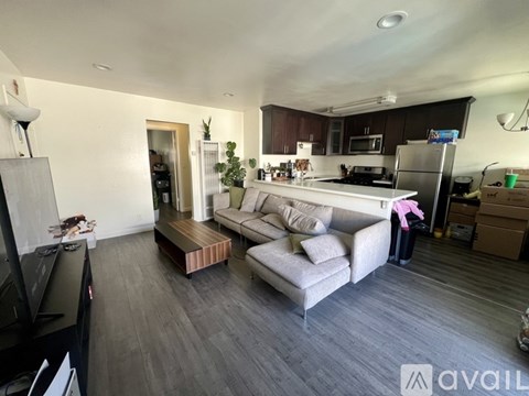 A modern kitchen with a grey couch and a wooden coffee table.