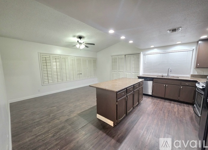 A kitchen with brown cabinets and a wooden island.