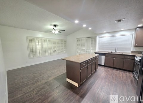 A kitchen with brown cabinets and a wooden island.