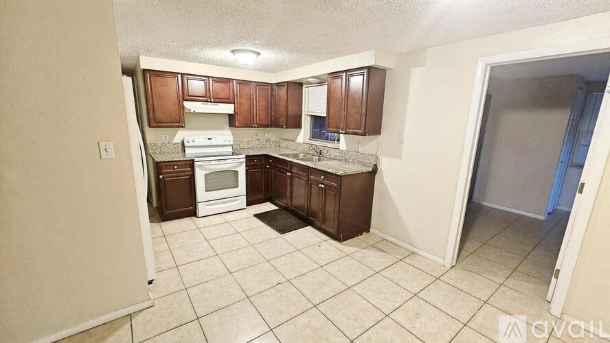 A kitchen with brown cabinets and a white dishwasher.