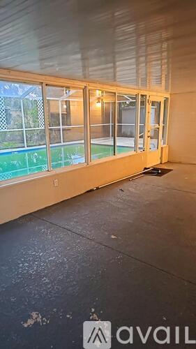 A room with a large window and a view of a pool outside.