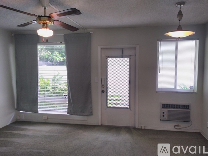 A room with a ceiling fan, a door, and a window with blinds.