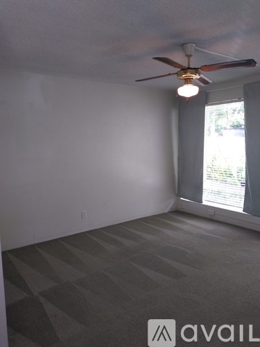 A room with a ceiling fan and a window.