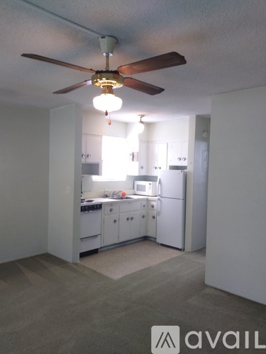 A kitchen with white cabinets and a ceiling fan.