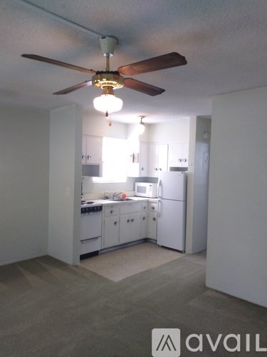 A kitchen with white cabinets and a ceiling fan.