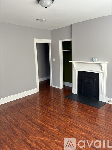 A room with a fireplace and wood flooring.