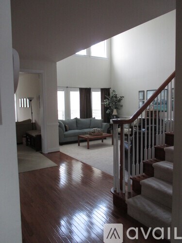 A living room with a couch and a staircase.