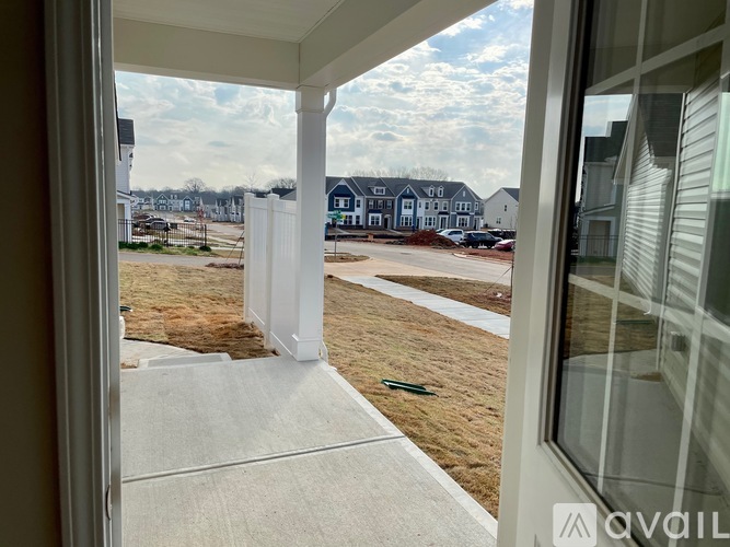 A view from a house looking out to a grassy area with a few houses in the distance.