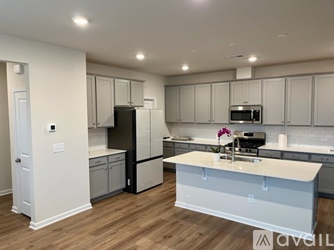 A kitchen with a refrigerator, microwave, and oven.