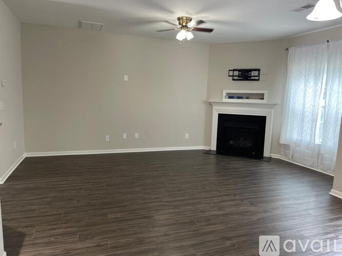 A living room with a fireplace and a flat screen TV mounted above it.