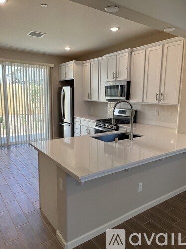A kitchen with white cabinets and appliances.