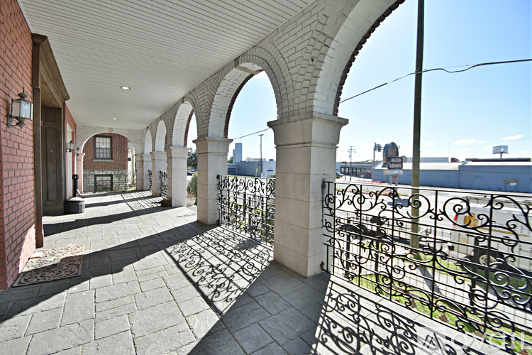 A balcony with arches and a metal railing.