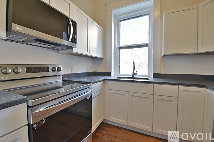 A kitchen with white cabinets and a stainless steel oven.