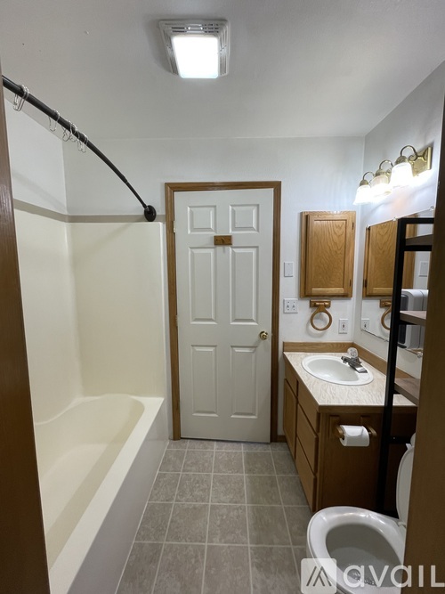 A bathroom with a white door and a white sink.