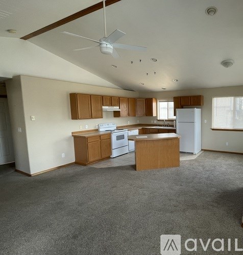 A kitchen with wooden cabinets and a white refrigerator.
