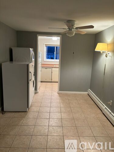 A kitchen with a white fridge and a ceiling fan.