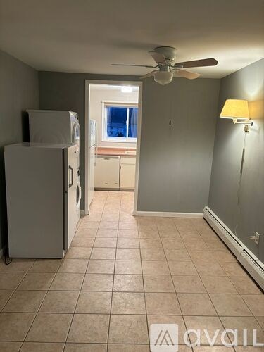 A kitchen with a white fridge and a ceiling fan.