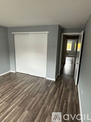 A room with wooden flooring and a white door.