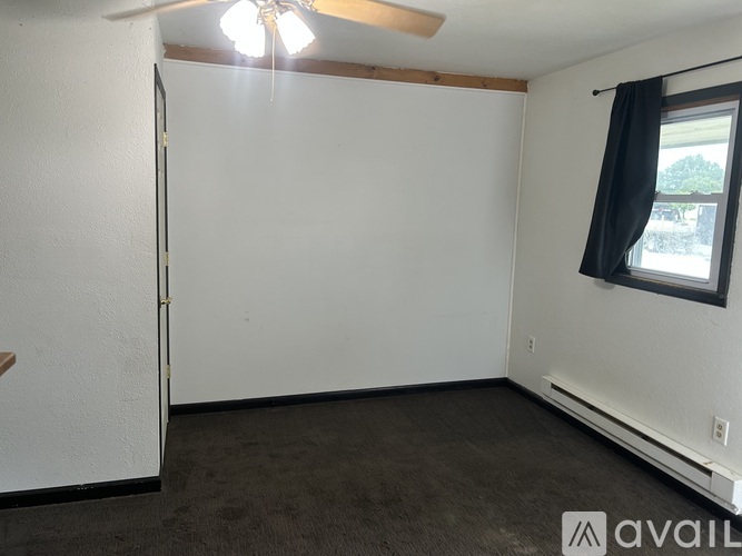 A room with a window and a ceiling fan.