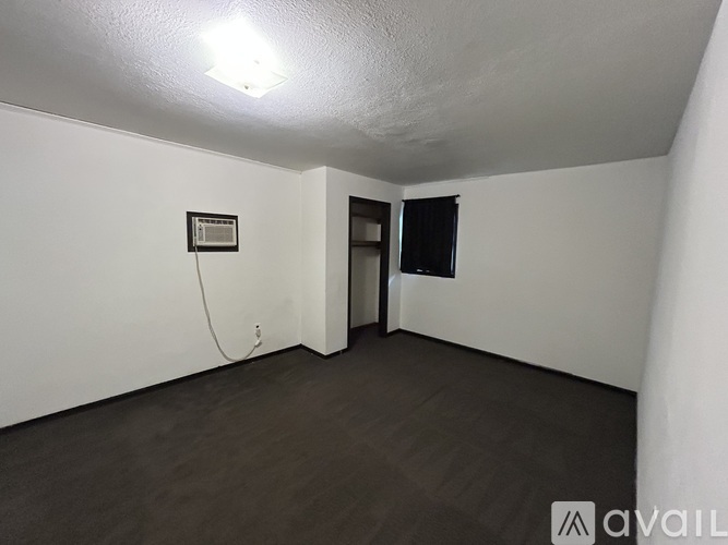 A room with a white wall and a black door.