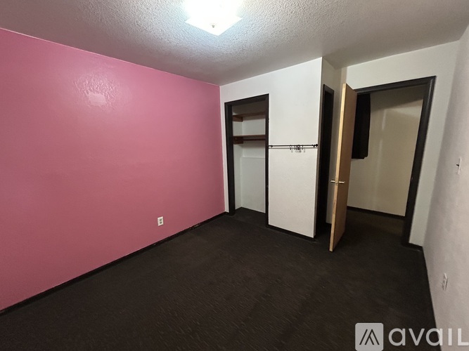 A room with pink walls and a white door.
