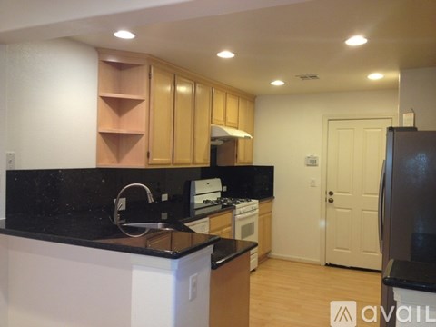 A kitchen with wooden cabinets and black countertops.