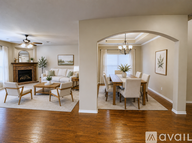 A living room with a fireplace and a dining table.