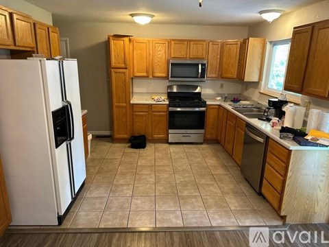 A kitchen with wooden cabinets and a white refrigerator.