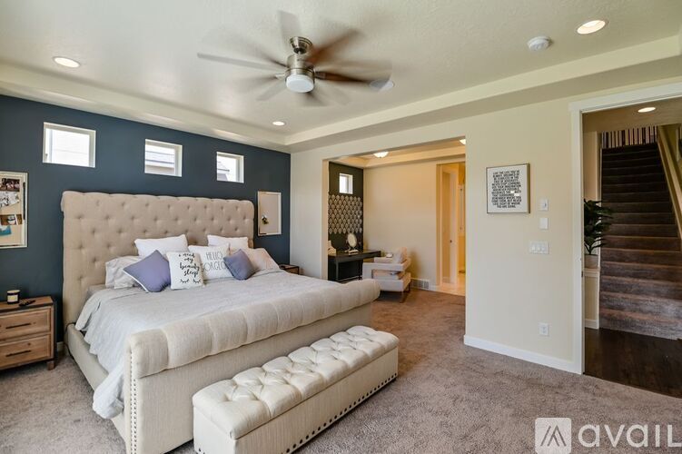 A bedroom with a large bed and a ceiling fan.