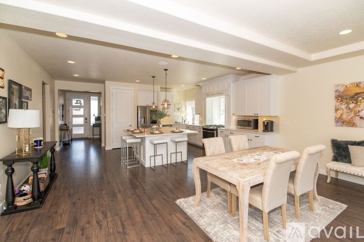 A spacious dining room with a white table and chairs.