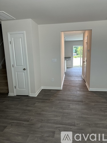 A room with a white door and a wooden floor.