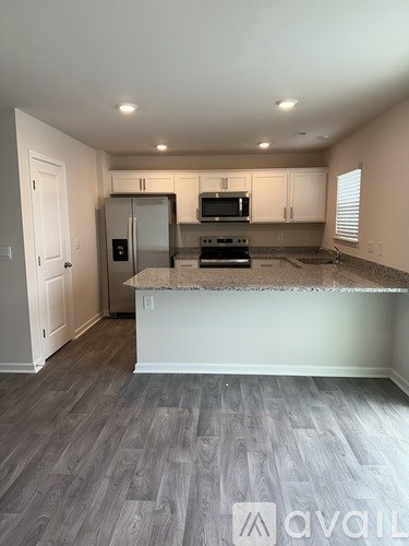A kitchen with a refrigerator, microwave, and oven.