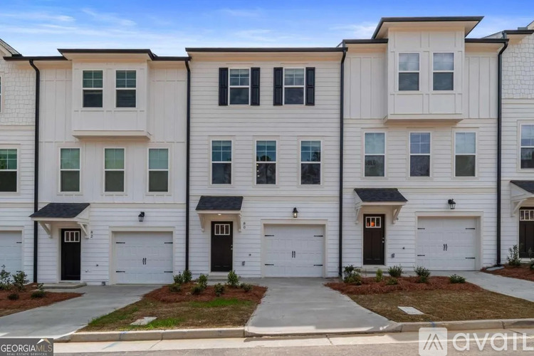 A row of modern townhouses with white and black garage doors.