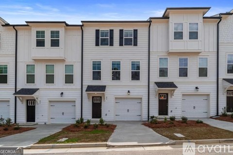A row of modern townhouses with white and black garage doors.