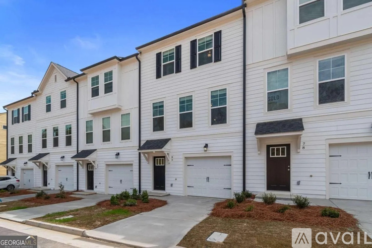 A row of townhouses with garages and a clear blue sky.