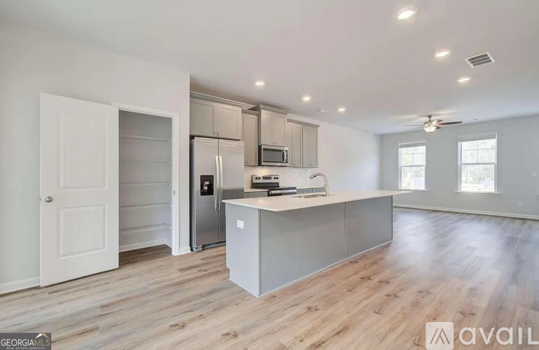 A kitchen with a refrigerator, microwave, and oven is available for rent.