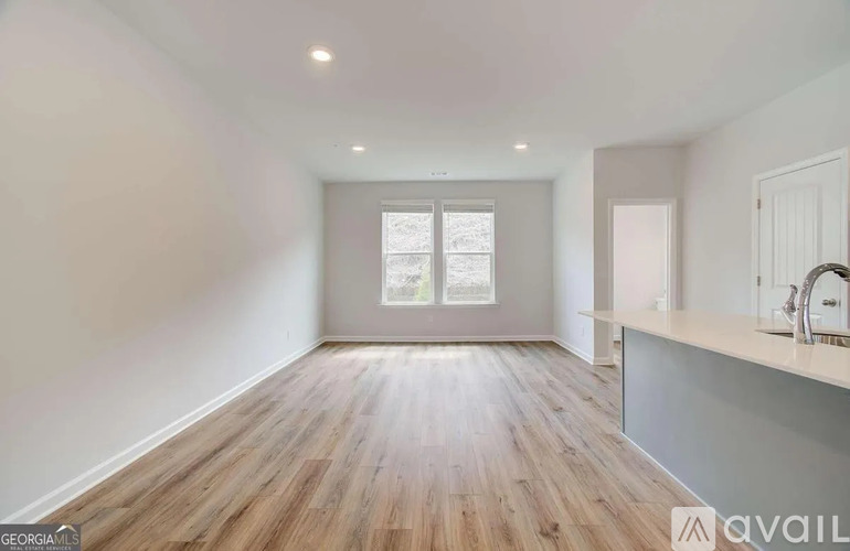 A spacious room with wooden flooring and a window.