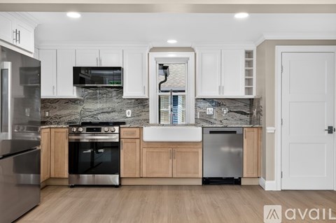 A kitchen with a marble backsplash and stainless steel appliances.
