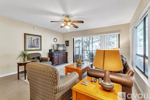 A living room with a brown chair and a lamp on a table.