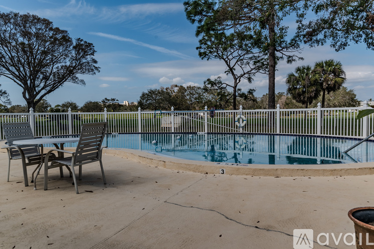 A pool with a table and chairs in front of it.