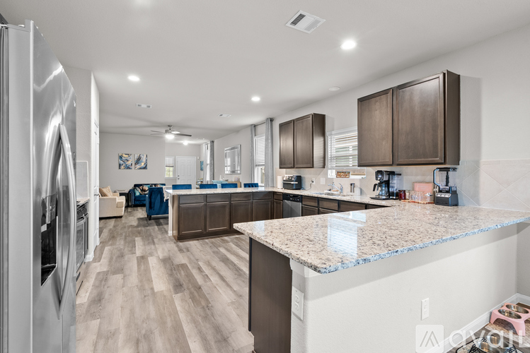 A modern kitchen with a refrigerator on the left and a countertop on the right.