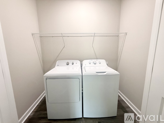 Two white front loading washing machines in a laundry room.